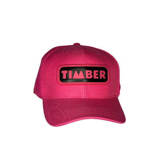 Boné rosa com aba curva e logo "TIMBER" em preto com contorno rosa ao centro.