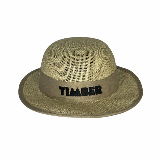 Chapéu de palha natural com aba média e fita bege decorativa. O logo "TIMBER" está bordado em preto, centralizado na parte frontal.