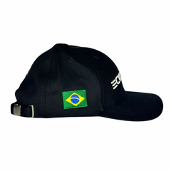 Boné preto com bordado da bandeira do Brasil na lateral. Mostra também um fecho metálico 