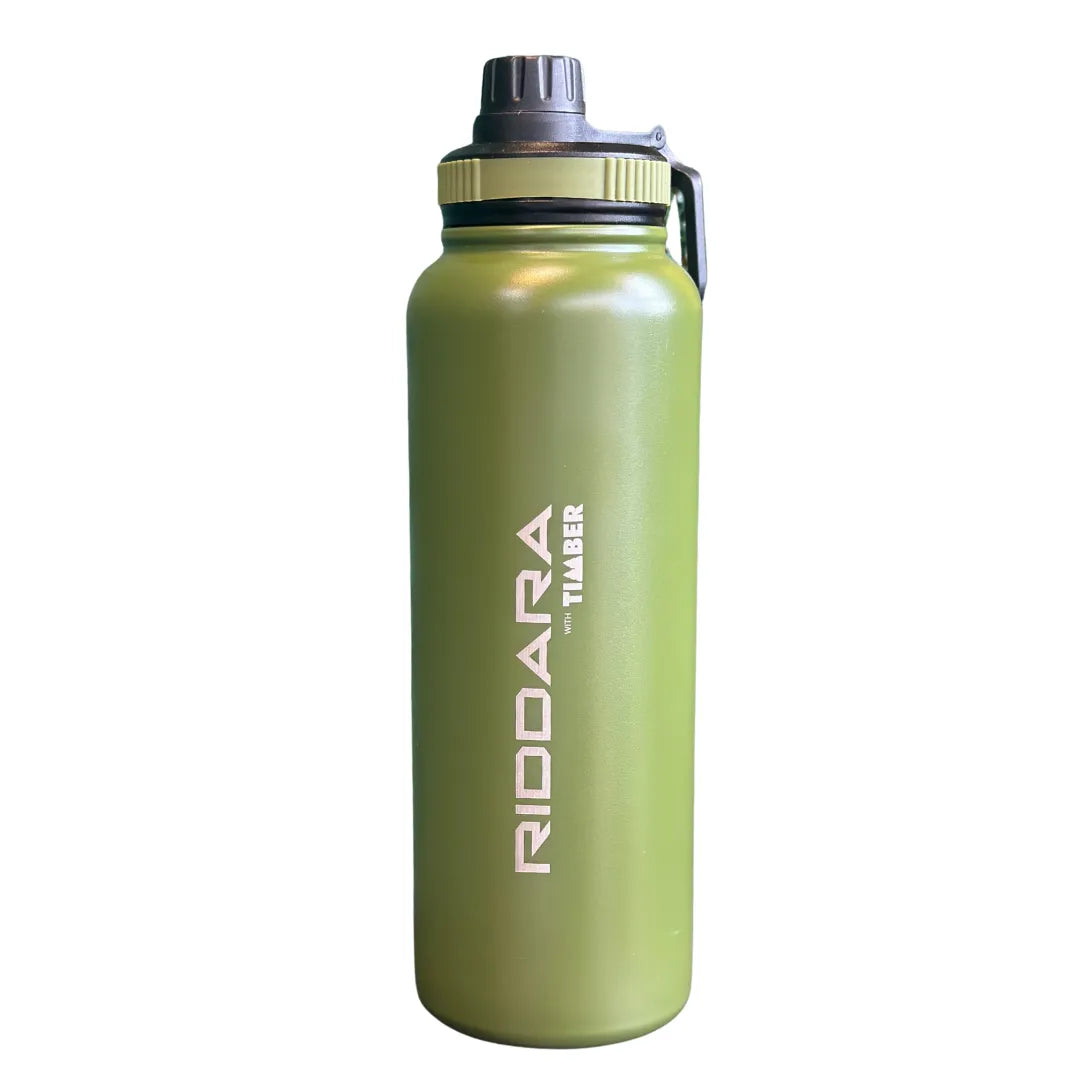 Acabamento sofisticado na cor verde militar, ideal para aventuras ao ar livre. Tampa preta com detalhe em verde e alça lateral prática. Inscrição "RIDDARA with TIMBER" em branco na lateral, reforçando a identidade da marca.