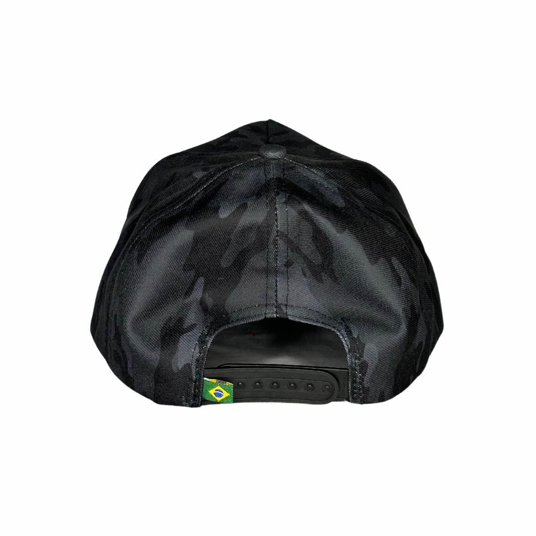 Fecho ajustável em plástico preto e detalhe da bandeira do Brasil na parte inferior.