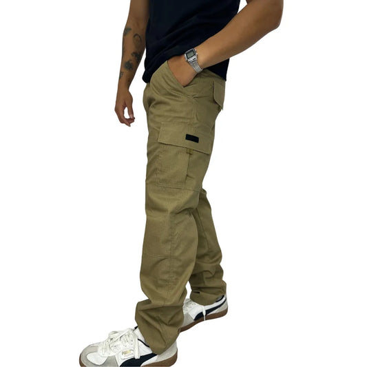 Calça masculina cargo Caqui com bolsos funcionais, ajuste lateral e logo "TIMBER" em amarelo.